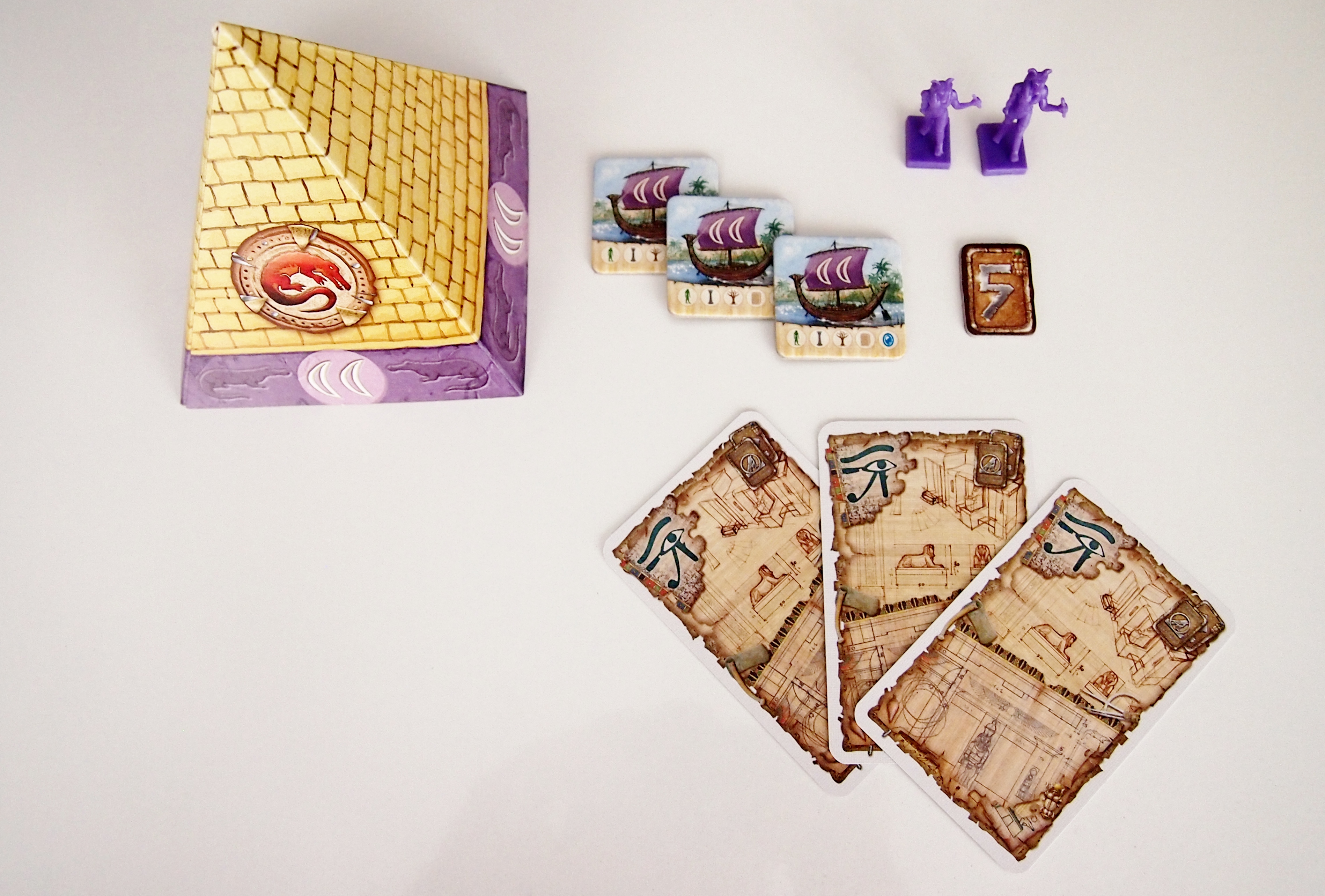 Cada jugador recibe tres cartas, cinco talentos, sus dos estatuas, tres Mercaderes del Nilo y una pirámide para ocultar los amuletos de corrupción. 