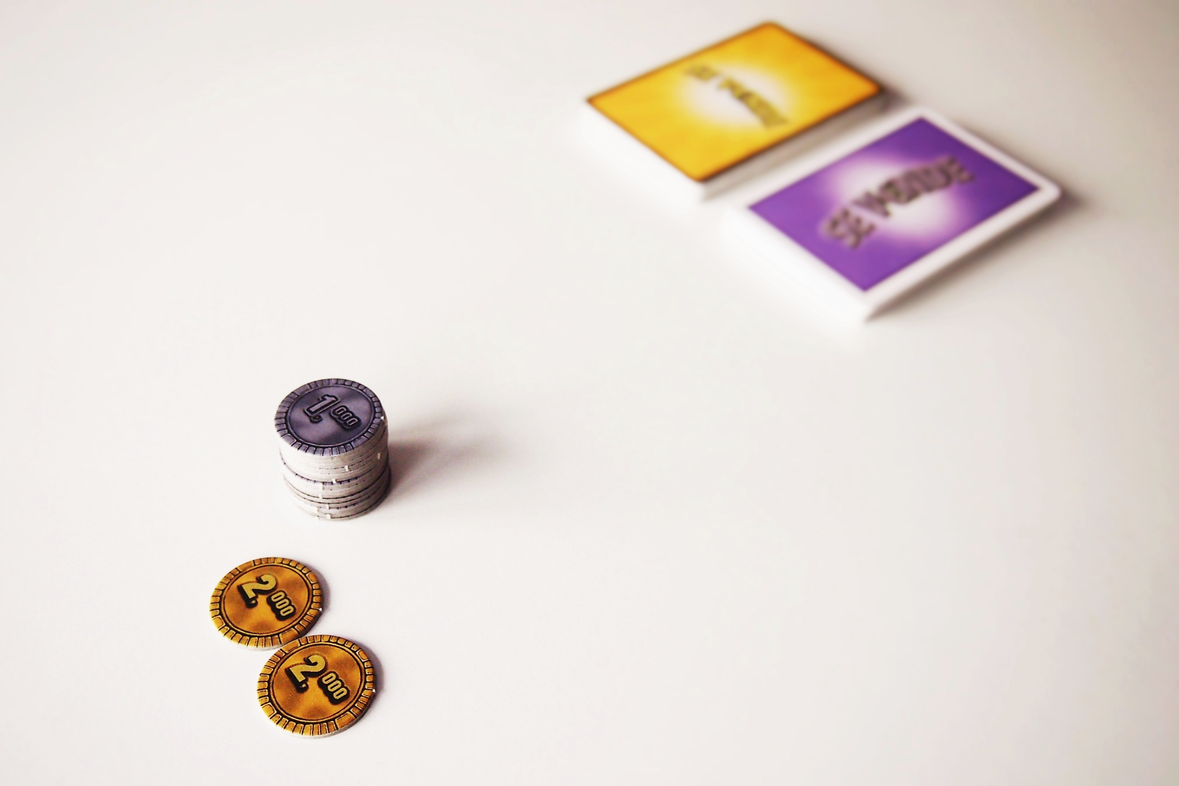 Antes de empezar, se reparten monedas a los jugadores (varían en función del número) y se separan las cartas en mazos. 